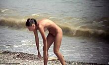 Тъмнокоса гола мацка се разхожда гола на плажа