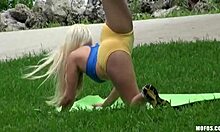 Gadis yoga berambut pirang berlatih di taman awam