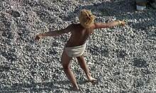 मौज-मस्ती करने वाली ब्लोंड रेत में नाचती हुई