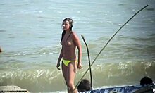 Nudist bir plajda dik göğüslerini gösteren üstsüz bomba